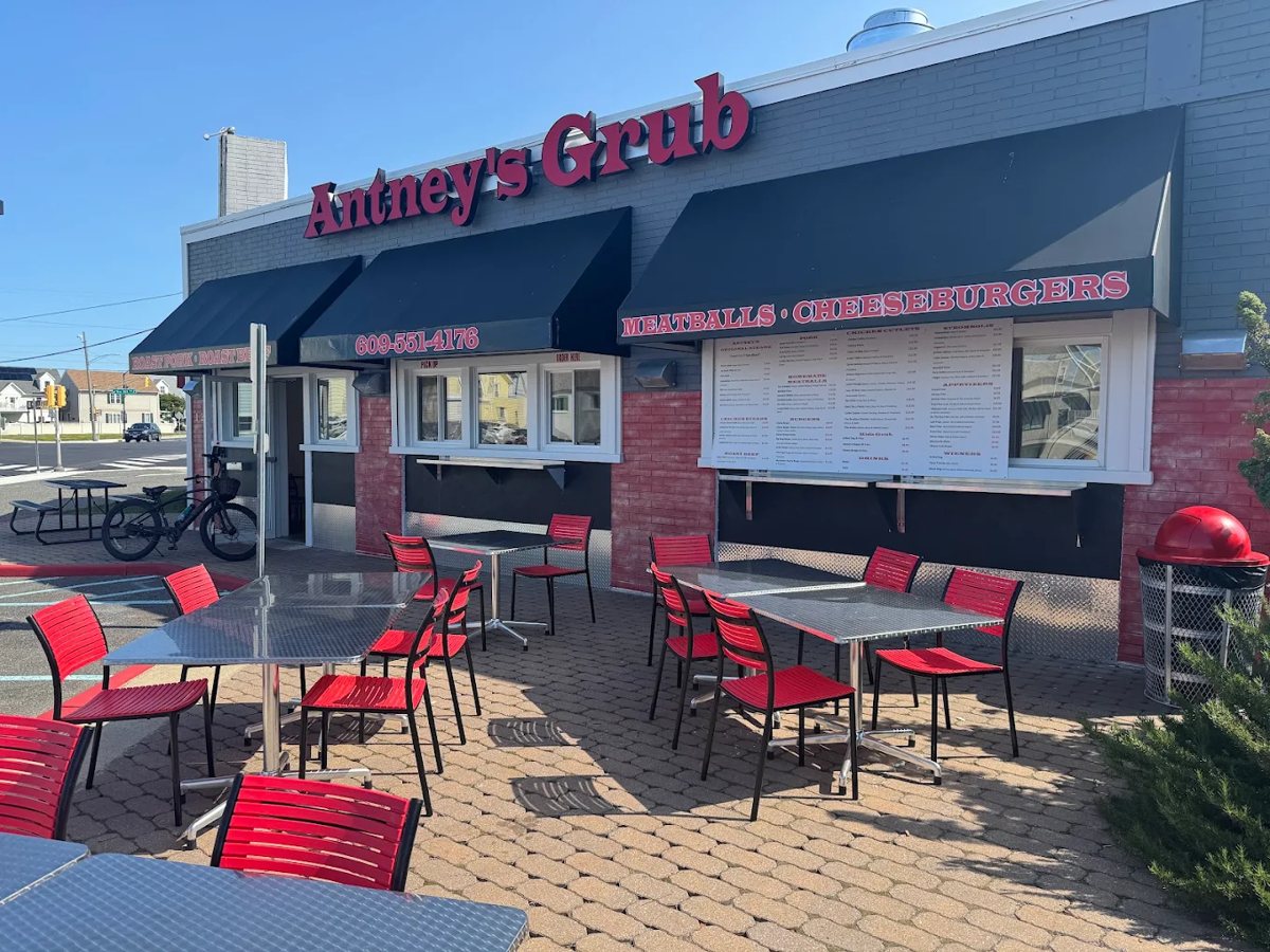 Outdoor patio seating with red chairs and steel tables outside the North Wildwood location